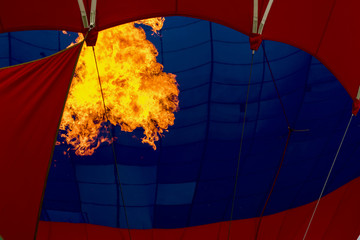 Close-up burning burner, bright flame against Hot air balloon. Preparing to launch a flying air balloon. Festival of balloons. With place for text, for background