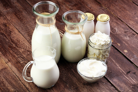 milk products - tasty healthy dairy products on a table on: sour cream in a white bowl, cottage cheese bowl, cream in a a bank and milk jar, glass bottle and in a glass