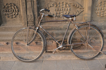 Old indian bicycle leaning on the temple wall.