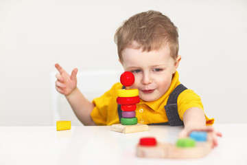 Concentrated little boy with toys on white background