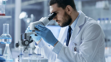 Research Scientist Looks into Microscope. He's Conducts Experiments in Modern Laboratory.