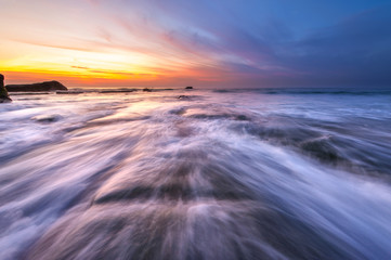Fototapeta na wymiar Long expose sunset with waves trails at Kudat Sabah Malaysia. Image contain soft focus due to long exposure.