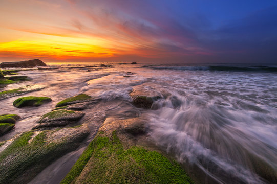 Colorful sunset with waves trails. Image contain soft focus due to long exposure.