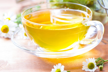 Tea herbs healing chamomile cup wooden background
