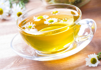 Tea herbs healing chamomile cup wooden background
