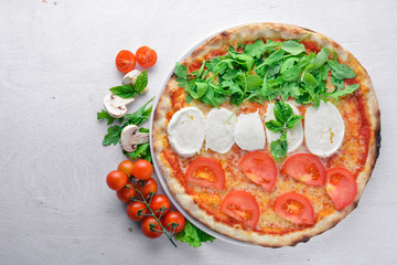 Pizza with vegetables and mozzarella. On a wooden background. Top view. Free space for your text.