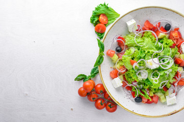 Greek salad of fresh vegetables and cheese. On a wooden background. Top view. Free space for your text.