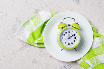 Alarm clock with bells on the plate, lunch time concept, top view with copy space
