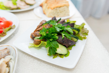 Sausage krovyanka, cut into pieces with fresh cucumber and greens close-up.