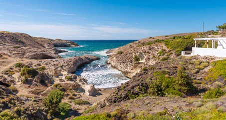 Kapros, small bay between rocks and blue sea on Milos island. Cyclades, Greece.