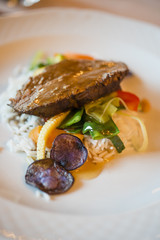 beef tagliata dish with white rice and vegetables.