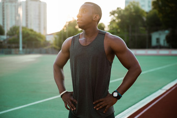 Young male athlete standing at the stadium race track