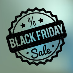 Black Friday rubber stamp black on a blue bokeh background.