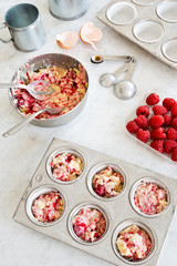 Making Raspberry Muffins or Cupcakes: Batter in Tins and Ingredients on Countertop