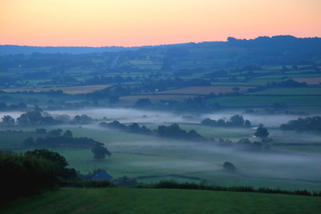 Naklejka premium Sunrise on a misty morning over Axe Valley in East Devon, England