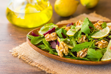 Salad with arugula, beets and nuts In a glass jar in a wooden plate