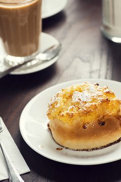 P&atilde;o de Deus, a Portuguese Sweet Bread with Coconut Topping, and a Latte in a Cafe