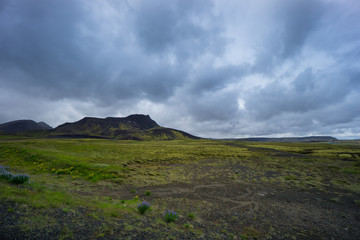 Fototapeta premium Iceland - Green volcanic mountains and dark clouds