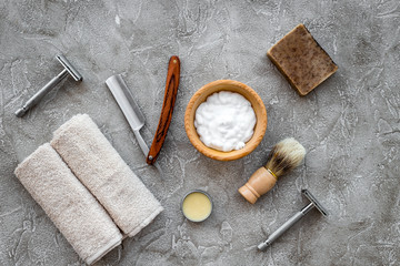 Fototapeta na wymiar Accessories for shaving. Shaving brush, razor, foam on grey stone table background top view