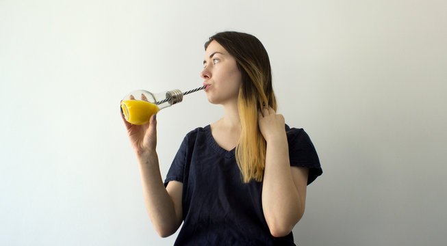 young woman holding glass of orange juice