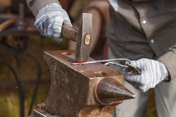 Blacksmith working on metal on anvil at forge high speed detail shot