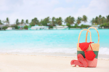 Fototapeta na wymiar Bag and beach accessories on sea shore. Summer vacation concept