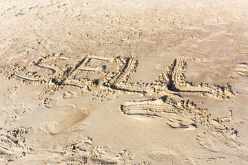 Sell written in the sand on a sunset beach