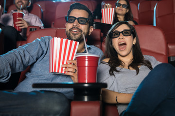 Surprised couple watching a 3d movie - obrazy, fototapety, plakaty