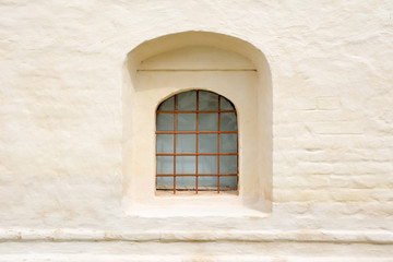 Fototapeta na wymiar Old barred window in a thick brick wall