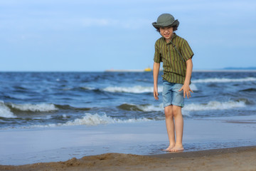 Happy boy playing on the sandy beach.