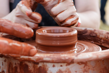 On the potter's wheel revolve a clay cup.