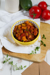 Leczo.Traditional hungarian stew or lecho with paprika,courgette and sausage. Served in a yellow bowl.