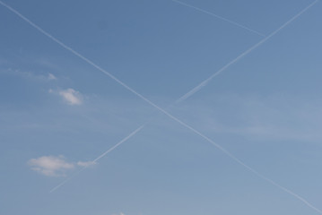 White cross lines on blue sky of two planes reversible traces