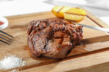 Delicious grilled steak on wooden board in restaurant