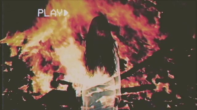 Fake VHS tape: the silhouette of a witch or ghost, a female with long hair, appears over the flames of a stake. Horror, Halloween, mystery.
