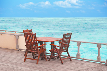 Table and chairs at sea beach on summer day