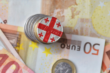 euro coin with national flag of georgia on the euro money banknotes background.