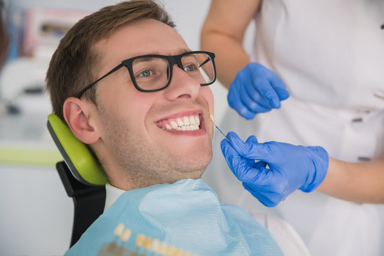 Man Smile With Healthy Teeth Whitening. Dental Care Concept. Set Of Implants With Various Shades Of Tone