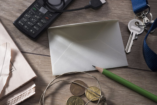 A sheet for writing on a table surrounded by objects of daily use.