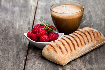 homemade  fresh panini bread with cup of cappuccino and raspberries