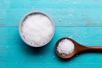 sea salt in bowl and in spoon on wooden background