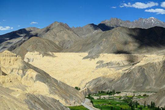 Tourist during expedition in the mountains Ladakh is admiring the beautiful Karakorum panorama in the vicinity of the Lamayuru town. Local are naming this rock formation with \"Martian earth\"