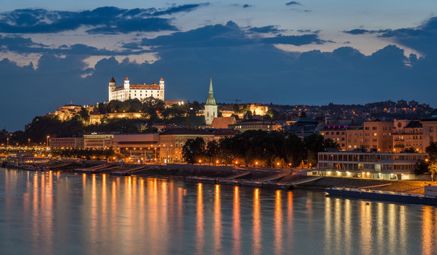 Bratislava castle at night with light reflection on the dunaj river on right riverside.