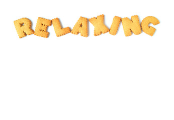 Top view of the word RELAXING, made with alphabet shaped biscuits on white background, with free space for text and design 