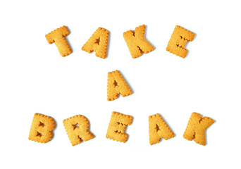 The word TAKE A BREAK spelled with alphabet shaped biscuits on white background 