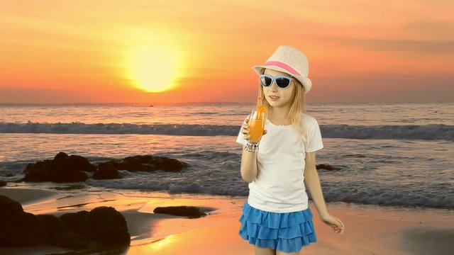 Young caucasian girl standing and drinking orange juice cocktail through straw. Sunset sea coast horizon. Girl drinking orange juice. Have same clip with transparent background Alpha Channel.