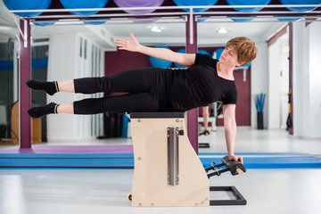 Woman exercising on combo wunda pilates chair