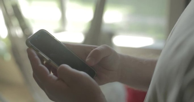 A man uses his smart phone at home.