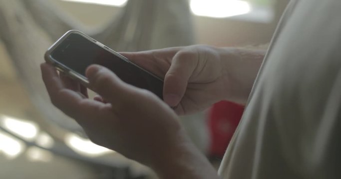A man uses his smart phone at home.