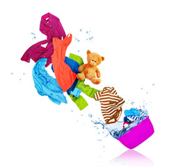 Colorful clothes flying out from wash bowl on white background